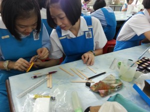 They are making the bookmarks using ice cream sticks.